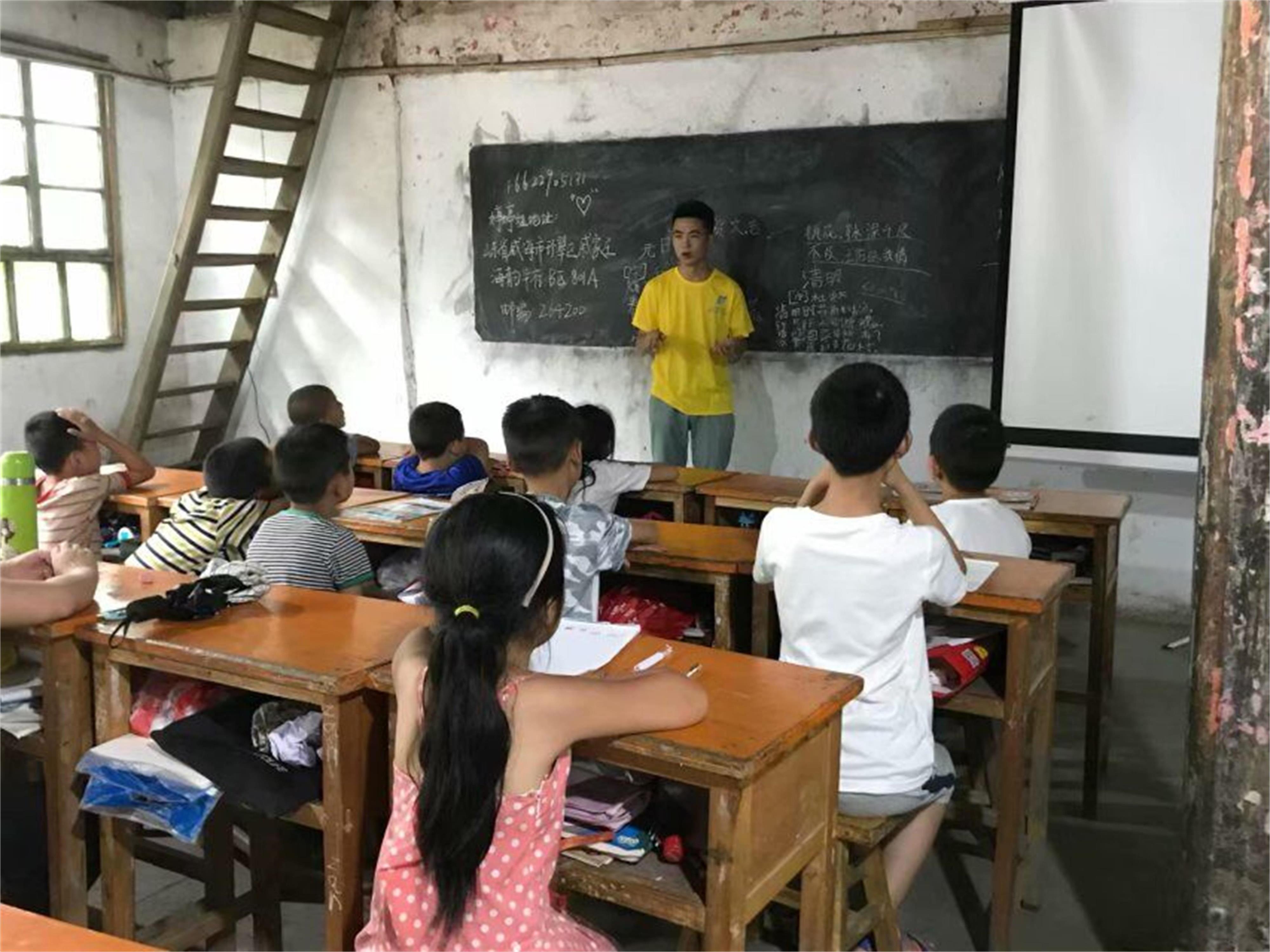 图为志愿者给三、四年级孩子上语文课。