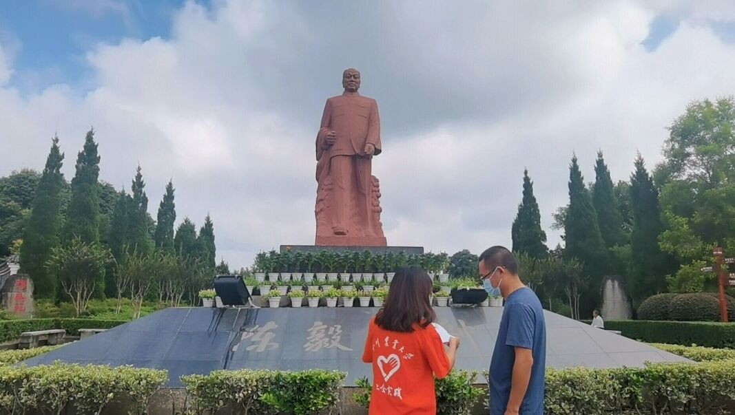 图为团队成员在陈毅铜像下为游客进行党史宣传。 陈恩慧 摄